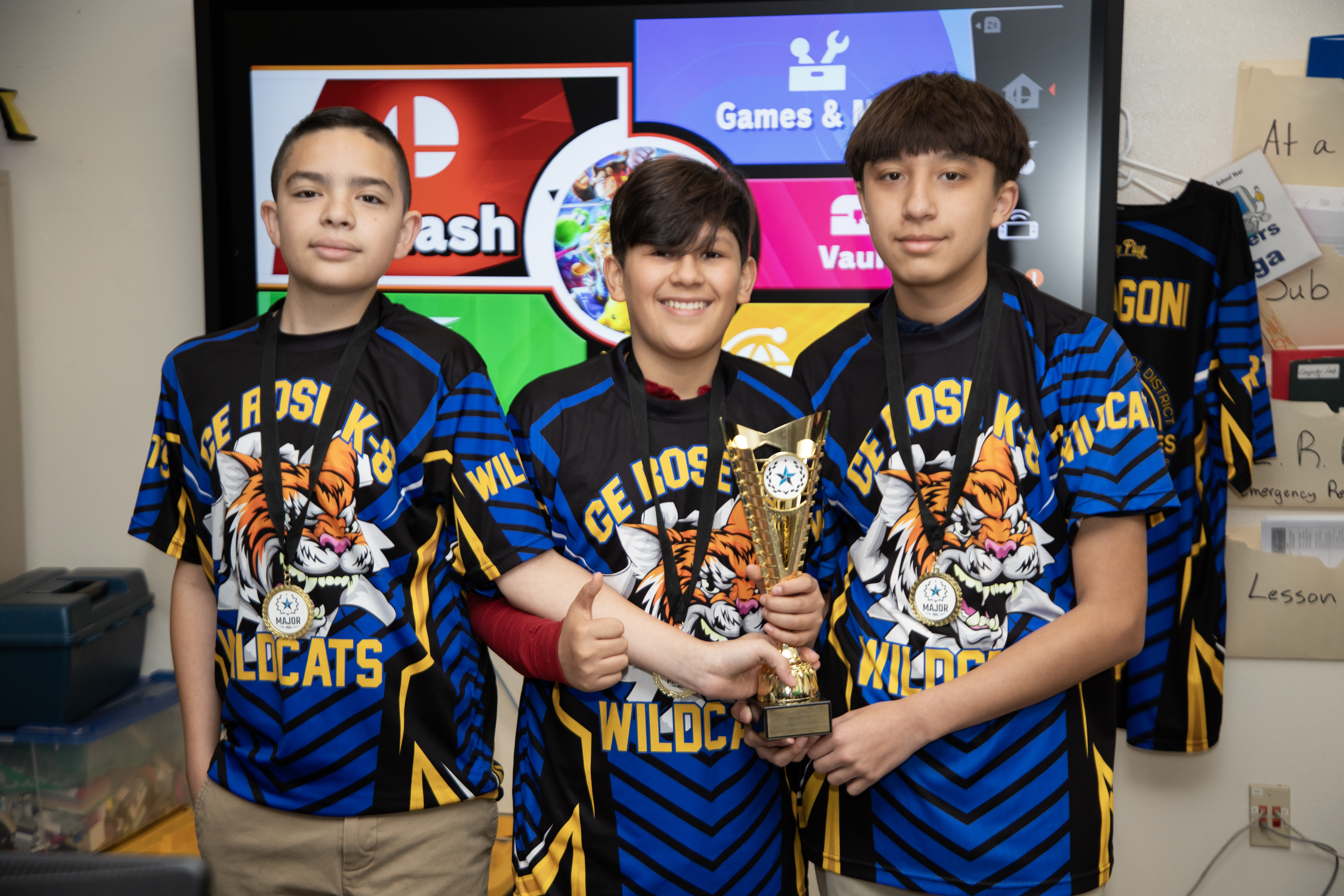 Three boys in CE Rose shirts show off their awards