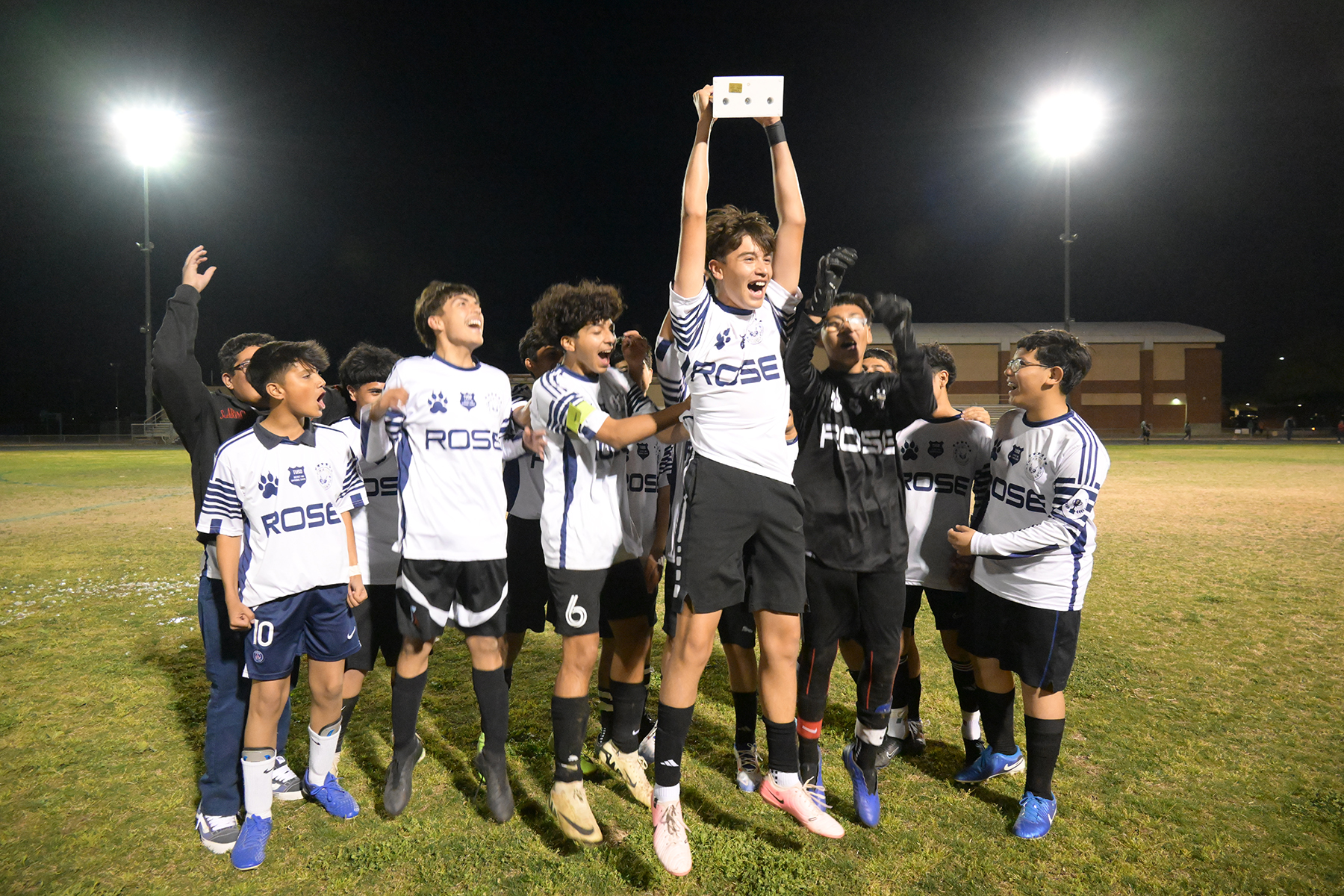 The boys team holds up their trophy