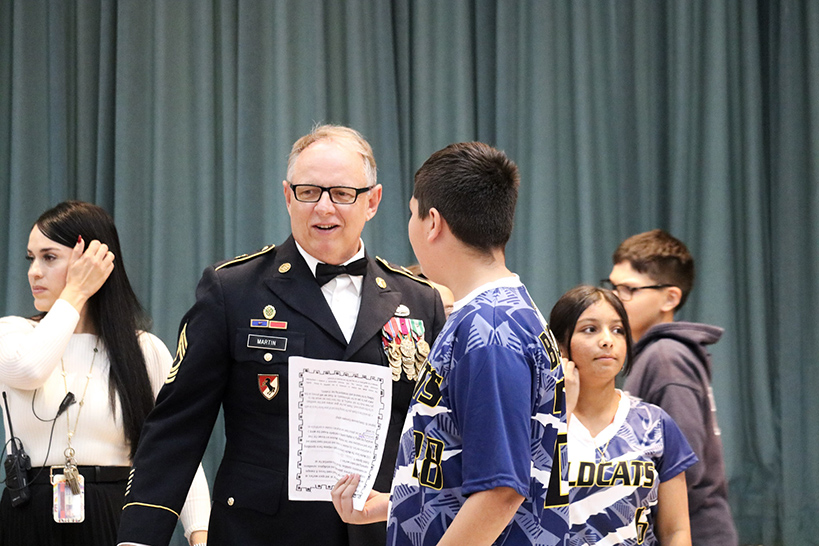 A veteran receives a certificate from a student