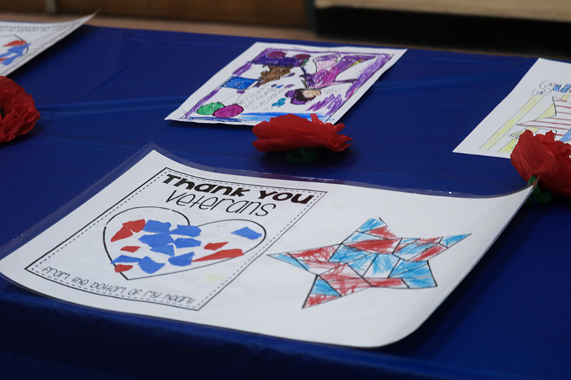 A coloring page with the words Thank You Veterans with a blue and red heart and star