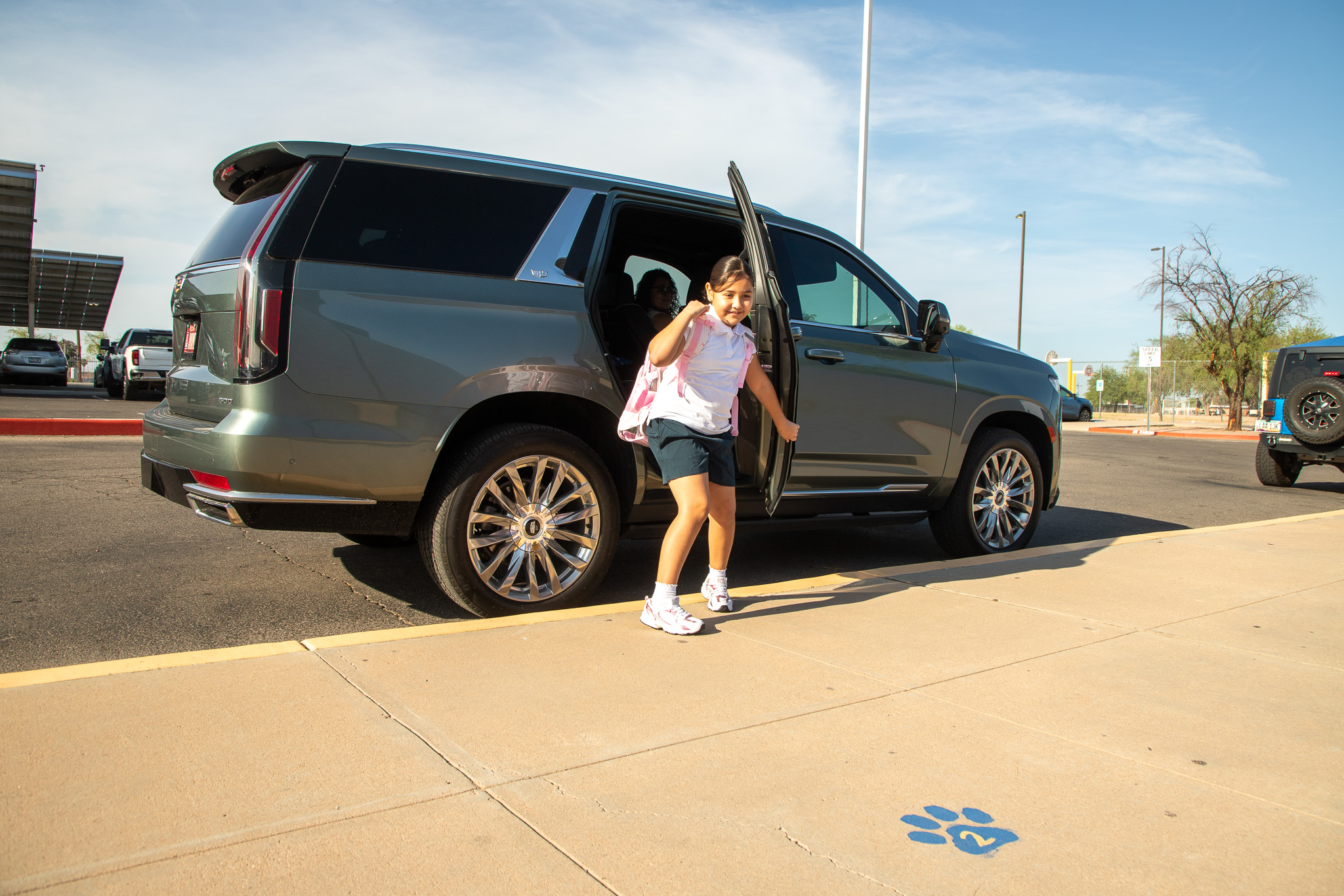 A girl gets out of her family's SUV